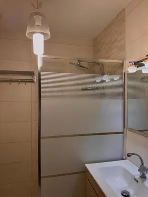 a bathroom with a sink and a shower and a mirror at Modern Apartment, Untouched & Ready to Stay in Amman