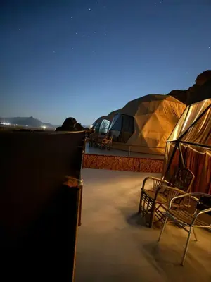 a tent and chairs on the deck of a boat at TAJ luxury Camp in Wadi Rum