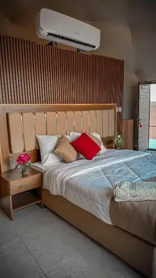 a bedroom with a large bed with red pillows at TAJ luxury Camp in Wadi Rum