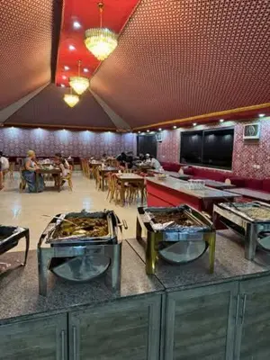 a restaurant with three tables with food on them at TAJ luxury Camp in Wadi Rum
