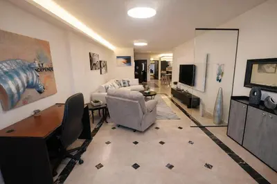 a living room with a couch and a tv at Abdoun Grand Family Apartment in Amman