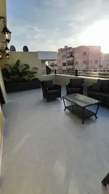 a balcony with couches and a table on a building at LaPerla Rooftop family in Amman