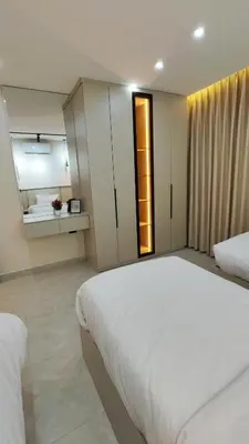 a bedroom with a large white bed and a mirror at LaPerla Rooftop family in Amman