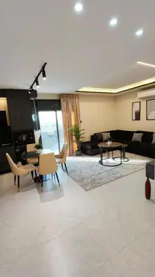 a living room with a couch and a table at LaPerla Rooftop family in Amman
