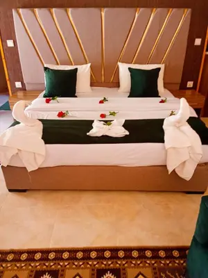 a bedroom with two beds with flowers on them at DESERT PULSE lUXURY CAMP in Wadi Rum