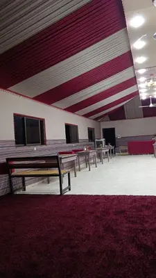 a room with rows of tables and a red rug at DESERT PULSE lUXURY CAMP in Wadi Rum