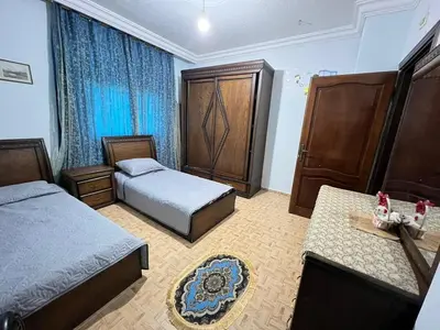 a hotel room with two beds and a dresser at Jad Apartment in irbid in Irbid