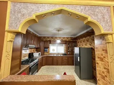 a kitchen with an archway in the middle of it at Jad Apartment in irbid in Irbid