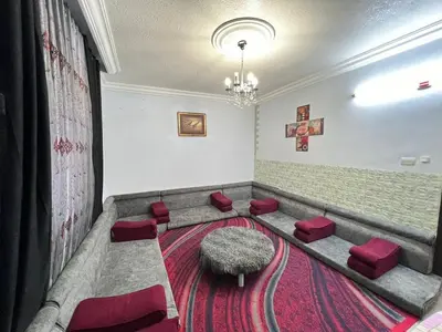 a waiting room with a bench and red stools at Jad Apartment in irbid in Irbid