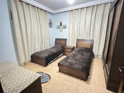 a bedroom with two beds in a room with curtains at Jad Apartment in irbid in Irbid