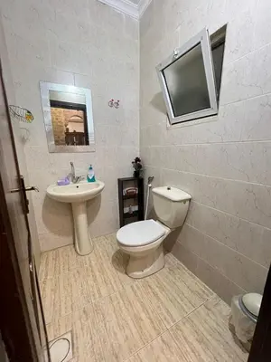 a bathroom with a toilet and a sink and a tv at Jad Apartment in irbid in Irbid