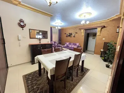 a dining room with a white table and chairs at Jad Apartment in irbid in Irbid