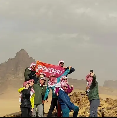 a group of people posing for a picture in the desert at Essam camb in Disah