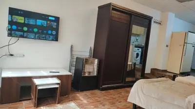a living room with a room with a television and a couch at Stone house in Amman