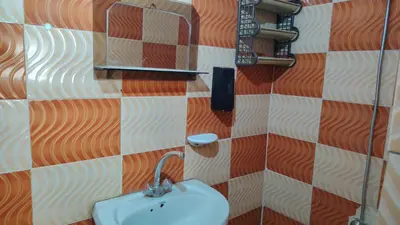 a bathroom with a sink and a checkerboard wall at Stone house in Amman