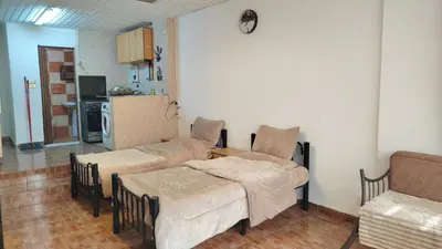 a living room with two beds and a kitchen at Stone house in Amman