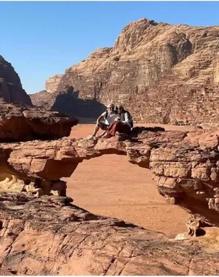 two people sitting on a rock in the desert at RUM BUBBLES DESERT lUXURY CAMP in Wadi Rum