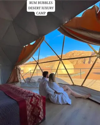a man and a woman sitting in a tent at RUM BUBBLES DESERT lUXURY CAMP in Wadi Rum