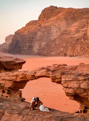 a dog sitting on a rock in the desert at rum magic luxury camp in Wadi Rum