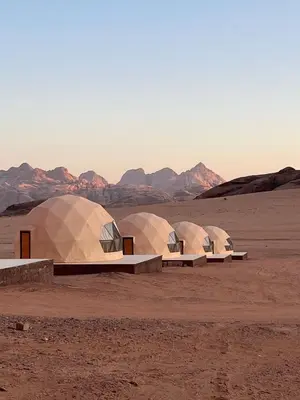 four domes in the desert with mountains in the background at rum magic luxury camp in Wadi Rum