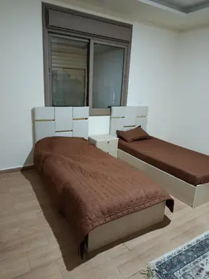 a bedroom with two beds and a window at شقه مفروشه للايجار بجانب الكارفور اربد in Irbid