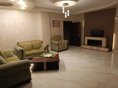 a living room with couches and a table and a television at شقه مفروشه للايجار بجانب الكارفور اربد in Irbid