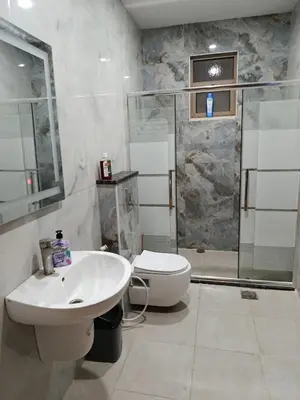 a bathroom with a shower and a sink and a toilet at شقه مفروشه للايجار بجانب الكارفور اربد in Irbid