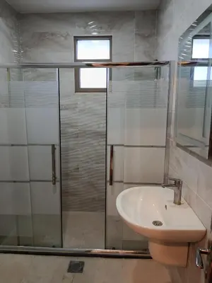 a bathroom with a sink and a glass shower at شقه مفروشه للايجار بجانب الكارفور اربد in Irbid
