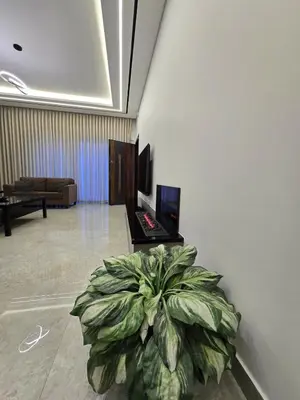 a large green potted plant in a room at Two-bedroom family friendly modern apartment in Amman