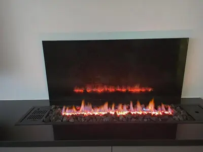 a large fireplace with fire in a room at Two-bedroom family friendly modern apartment in Amman