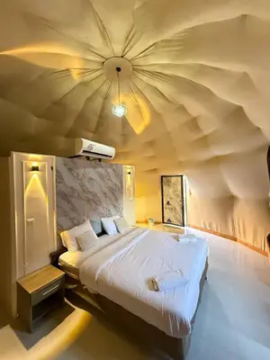 a bedroom with a large bed with a large ceiling at Golden Dunes Camp Wadi Rum in Wadi Rum