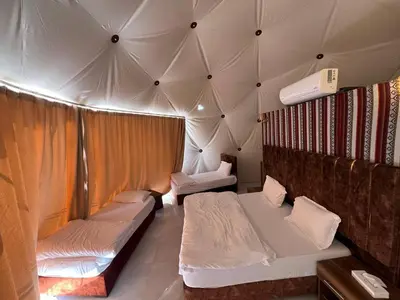 a room with two beds in a tent at Golden Dunes Camp Wadi Rum in Wadi Rum