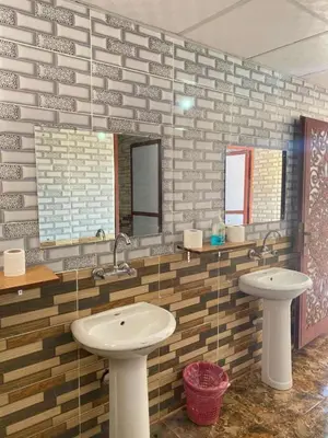 a bathroom with a sink and two mirrors at Enad wadirum camp in Wadi Rum