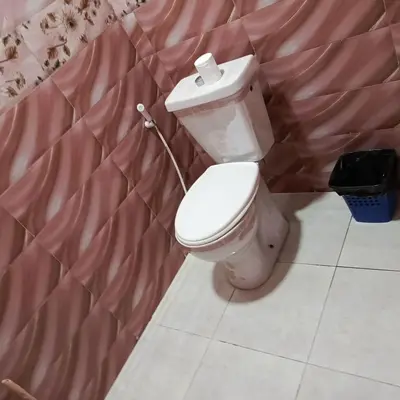 a bathroom with a toilet in a pink room at المناره هاوس in Wadi Musa
