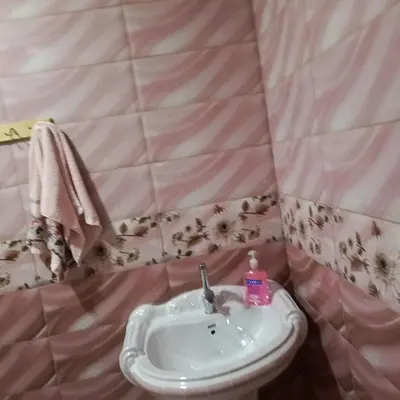 a bathroom with a sink and a pink wall at المناره هاوس in Wadi Musa