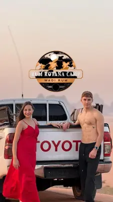 a man and a woman standing in front of a truck at WADi RUM ROTANA BUBBLE lUXURY CAMP in Wadi Rum