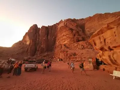 a group of people standing in front of a mountain at Bedouin Whispers Camp wadirum in Wadi Rum