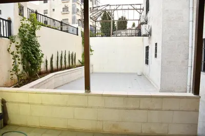 an empty courtyard in a building with a fence at شقة مفروشة مع ساحة خارجية قرب دوار اليوسفي in Irbid