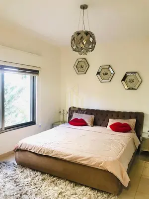 a bedroom with a large bed with red pillows on it at Chic 2-Bedroom - Fully Furnished in Amman