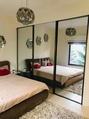 a bedroom with two beds and a large mirror at Chic 2-Bedroom - Fully Furnished in Amman