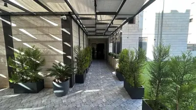 a hallway with potted plants on a building at Modern Apartment in Um Uthaina Amman in Amman