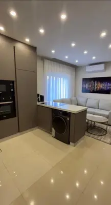 a kitchen and living room with a washer and dryer at Modern Apartment in Um Uthaina Amman in Amman