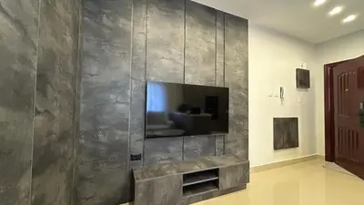 a living room with a television on a wall at Modern Apartment in Um Uthaina Amman in Amman