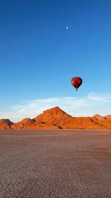 a person flying a kite in the desert at Wadi Rum Royal Camp in Disah