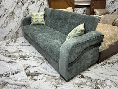 a green couch with two pillows sitting in a room at الكرك الثنية in Kerak