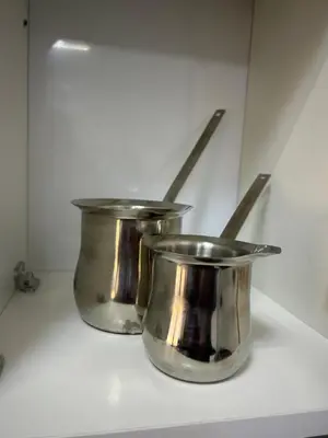 two metal pots sitting on top of a counter at golden apartment - karak in Kerak