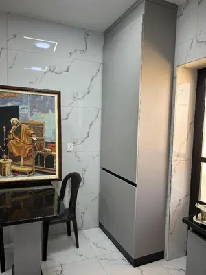 a painting on a wall next to a table and a chair at golden apartment - karak in Kerak