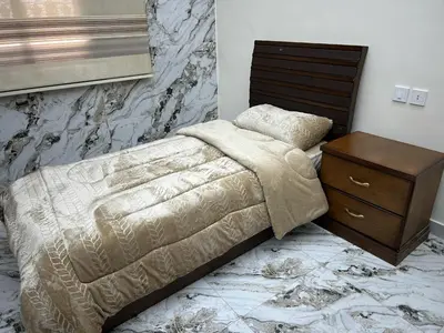 a bedroom with a bed with a nightstand and a bed sidx sidx sidx sidx at golden apartment - karak in Kerak