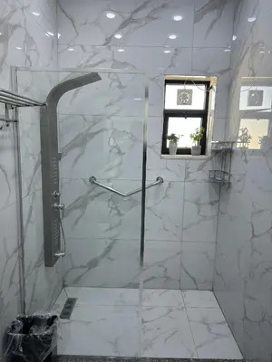 a white bathroom with a shower with a window at golden apartment - karak in Kerak