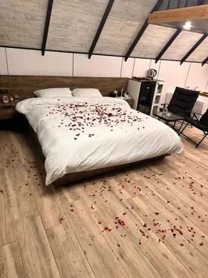 a bedroom with a bed with red flowers on the floor at منتجع وأكواخ غصن in Al Jafr